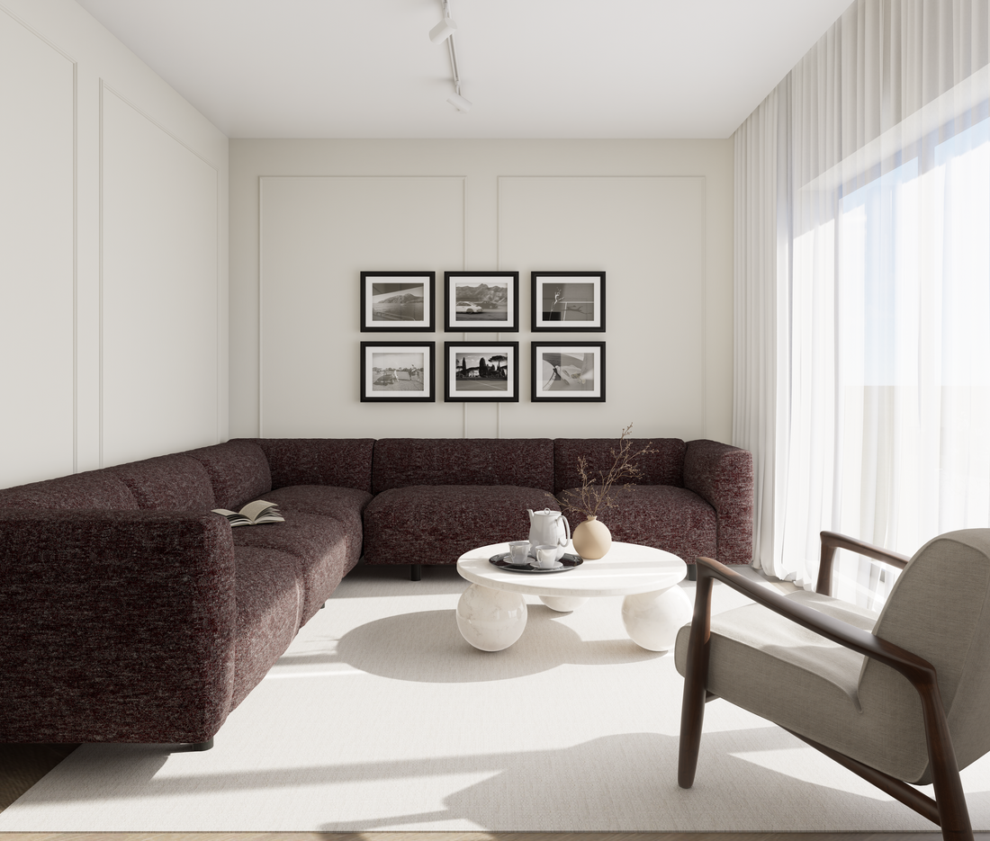 Cameră de zi în stil contemporan neo-clasic în tonuri neutre, cu canapea modulară maroon, lumină naturală amplă și accente minimaliste într-o atmosferă caldă și rafinată.